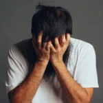 תמונה של גבר מכסה את הפנים עם הידיים מביע תסכול